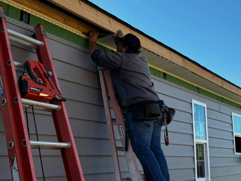a person hanging gutters on a home.